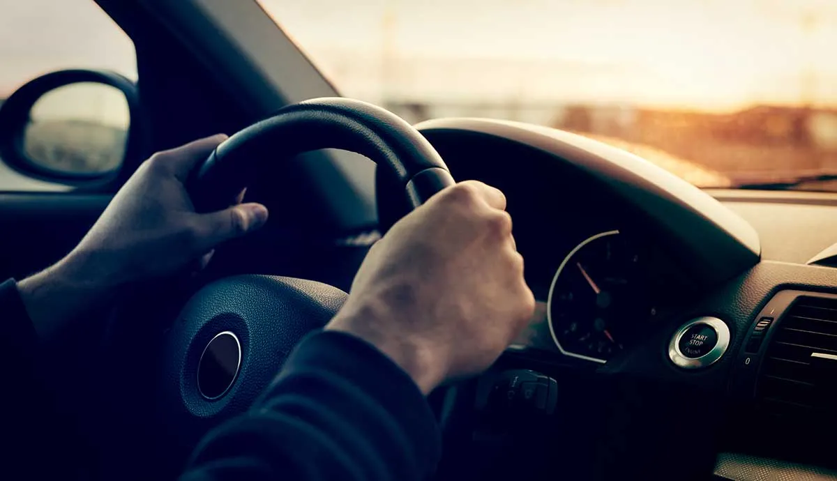 Driving a car in sunny day - focus on steering wheel