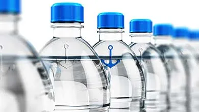 Close-up of clear water bottles with bright blue caps in a row on a white background; the front bottle displays a blue anchor logo.