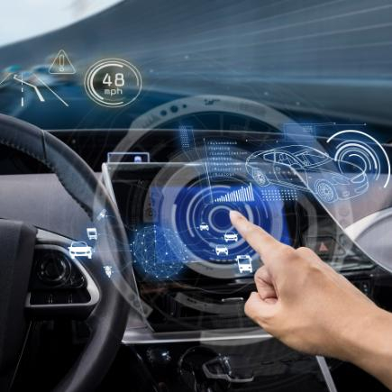A hand uses a holographic car dashboard display showing speed, navigation, and nearby vehicles.